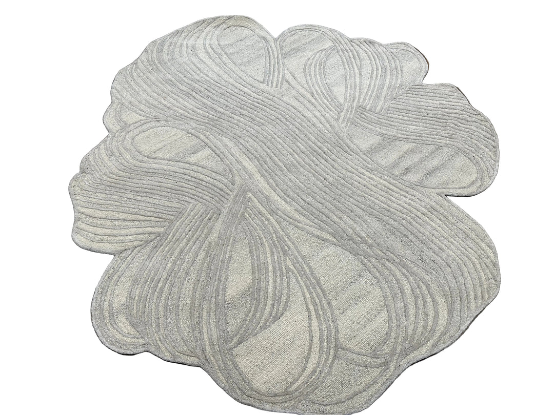 A round area rug with an abstract, organic wavy pattern in light gray and off-white tones, shown against a plain white background.