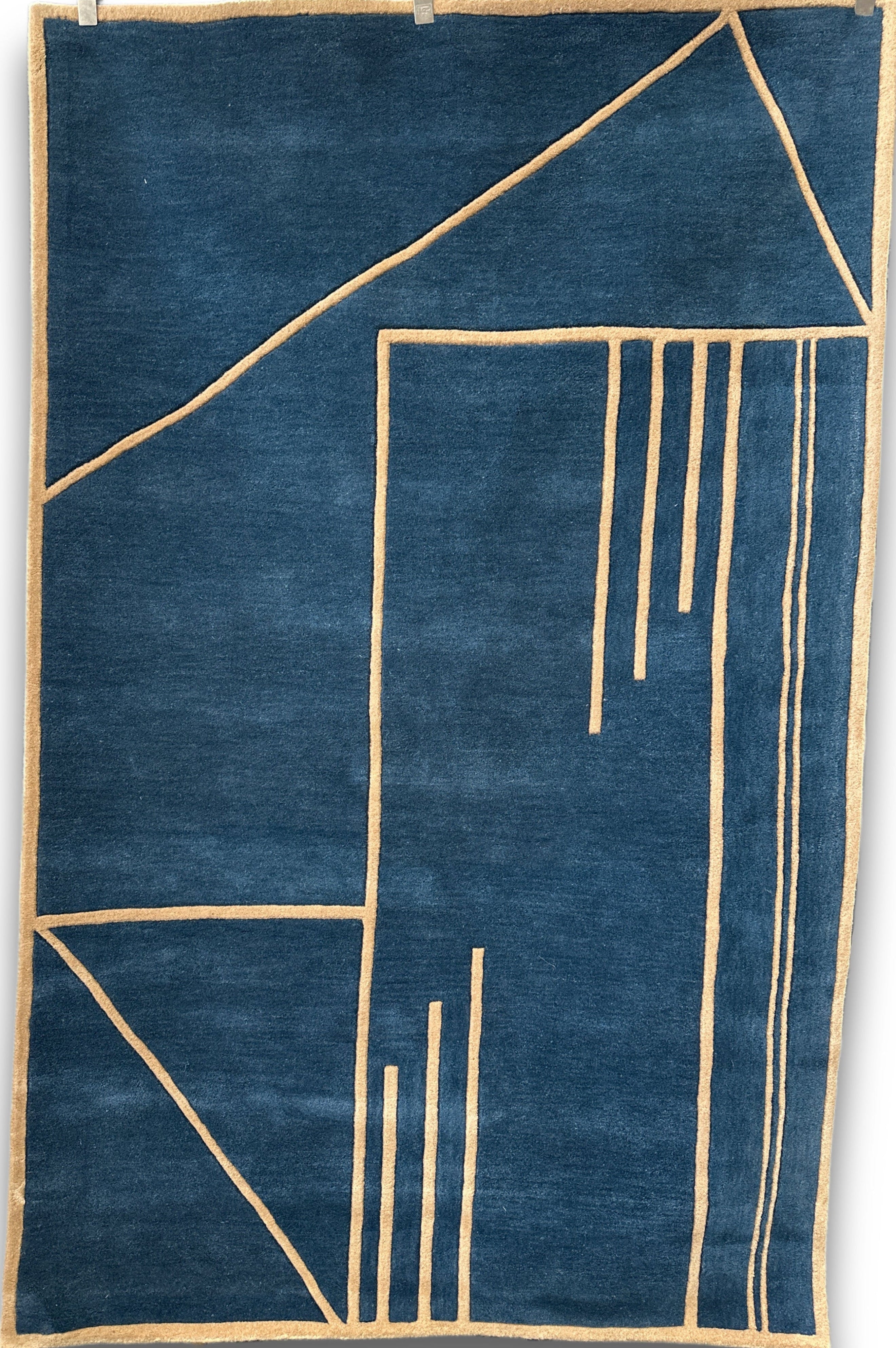 Blue rug with beige geometric patterns on a white background