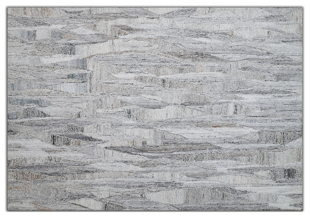 A modern geometric patterned area rug featuring shades of gray and white.