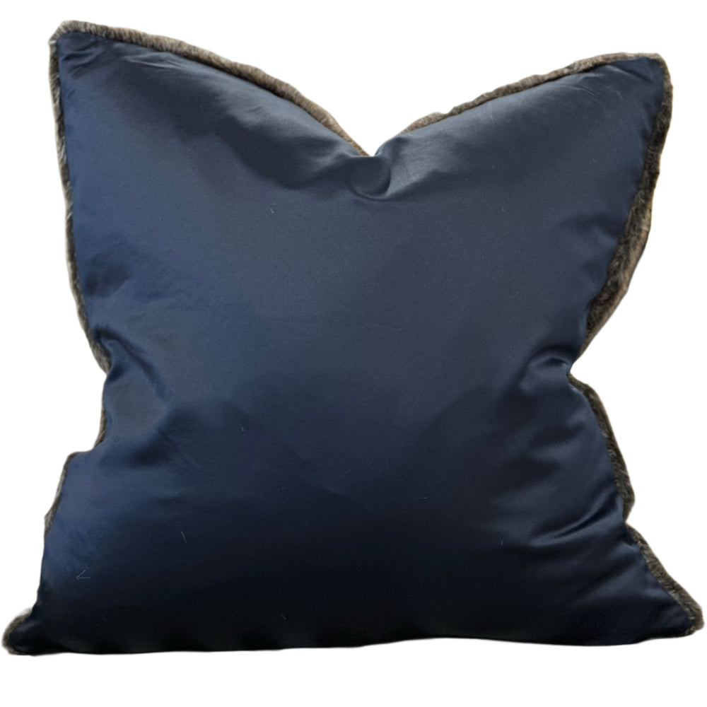 Navy blue pillow with brown trim on a white background