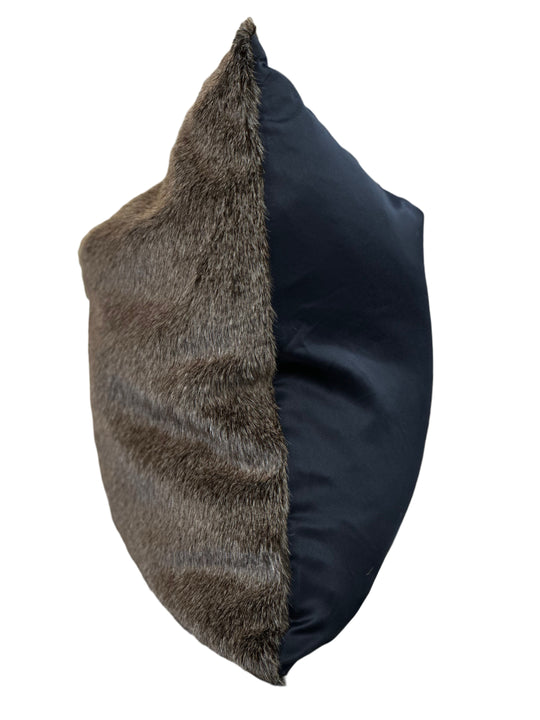Decorative pillow with fur and navy blue fabric on a white background