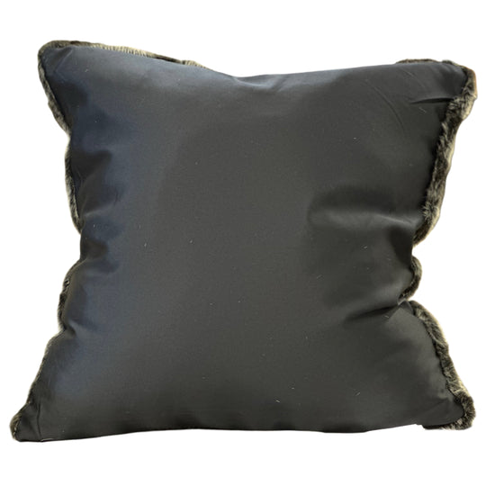 Black pillow with frayed edges on a white background