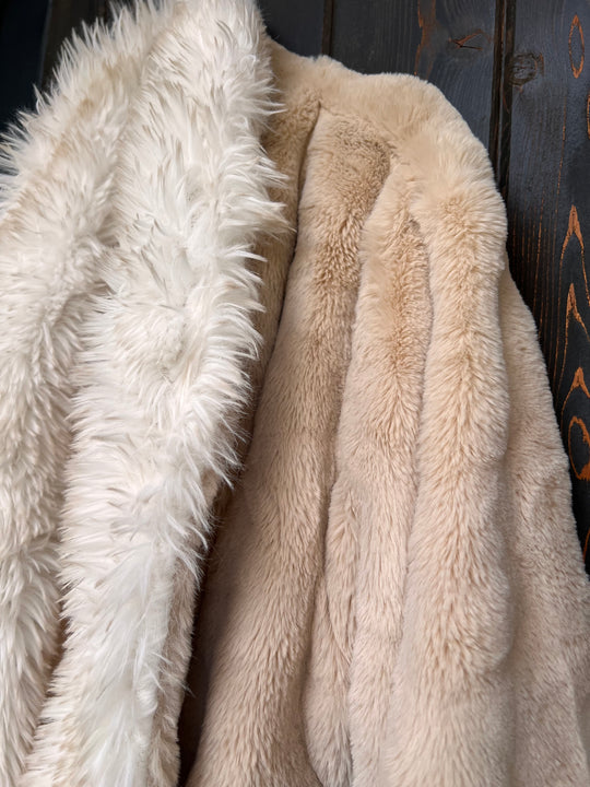 Close-up of beige and white fluffy fabric on a wooden surface