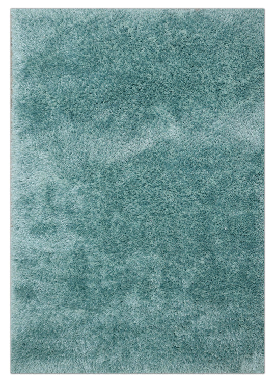 A close-up of a plush, high-pile shag rug in a dusty teal blue-green color, showing the soft texture of the fibers.
