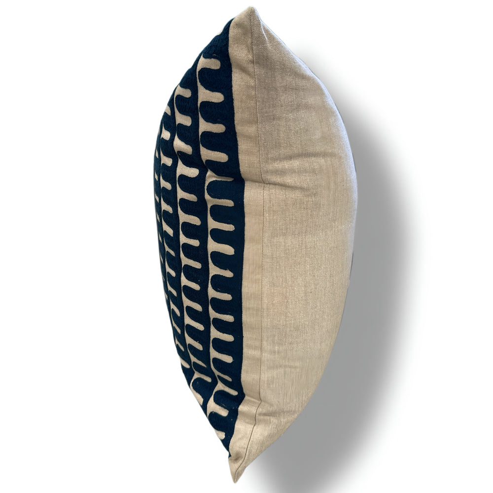 Decorative pillow with navy and beige pattern on a white background