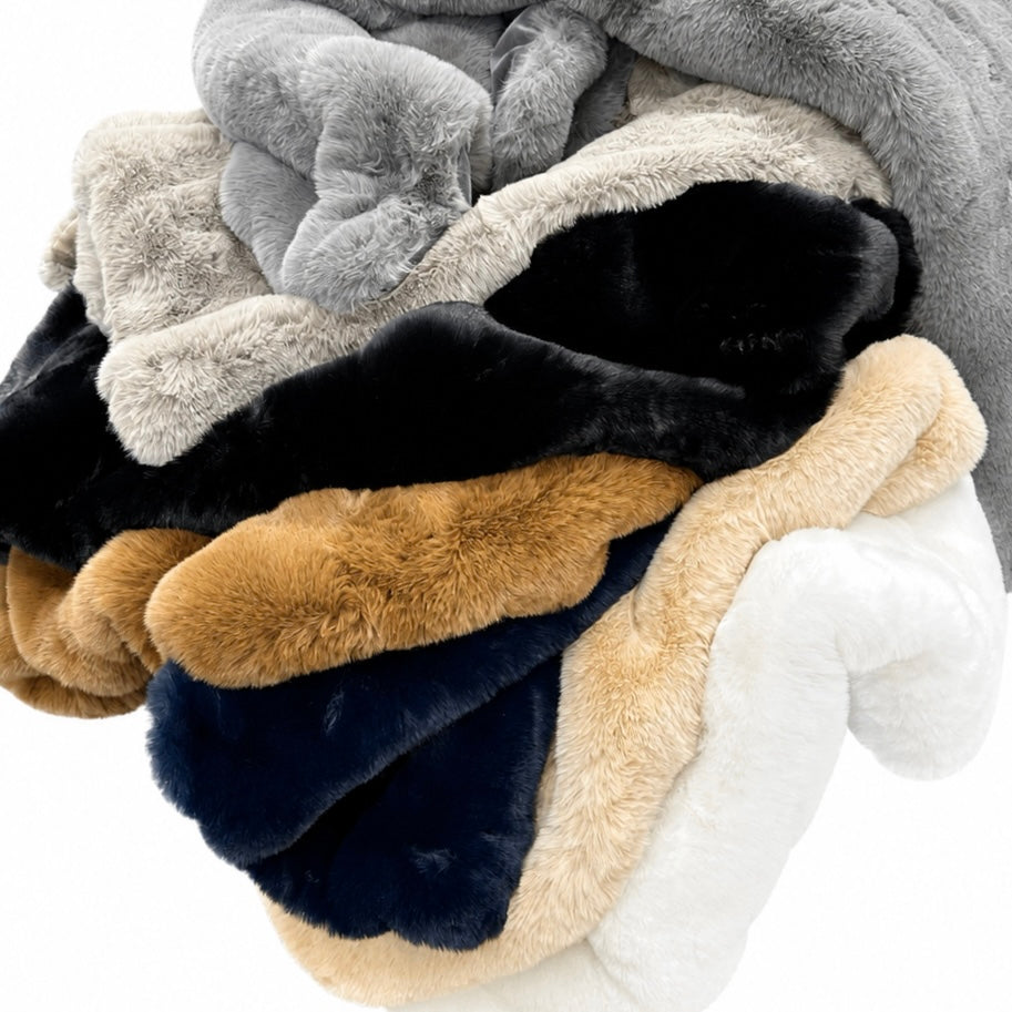 Stack of multicolored plush blankets on a white background