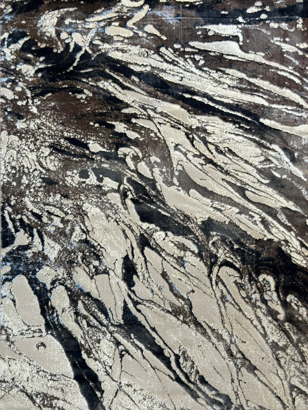 Abstract design area rug with shades of gray, black, and white.