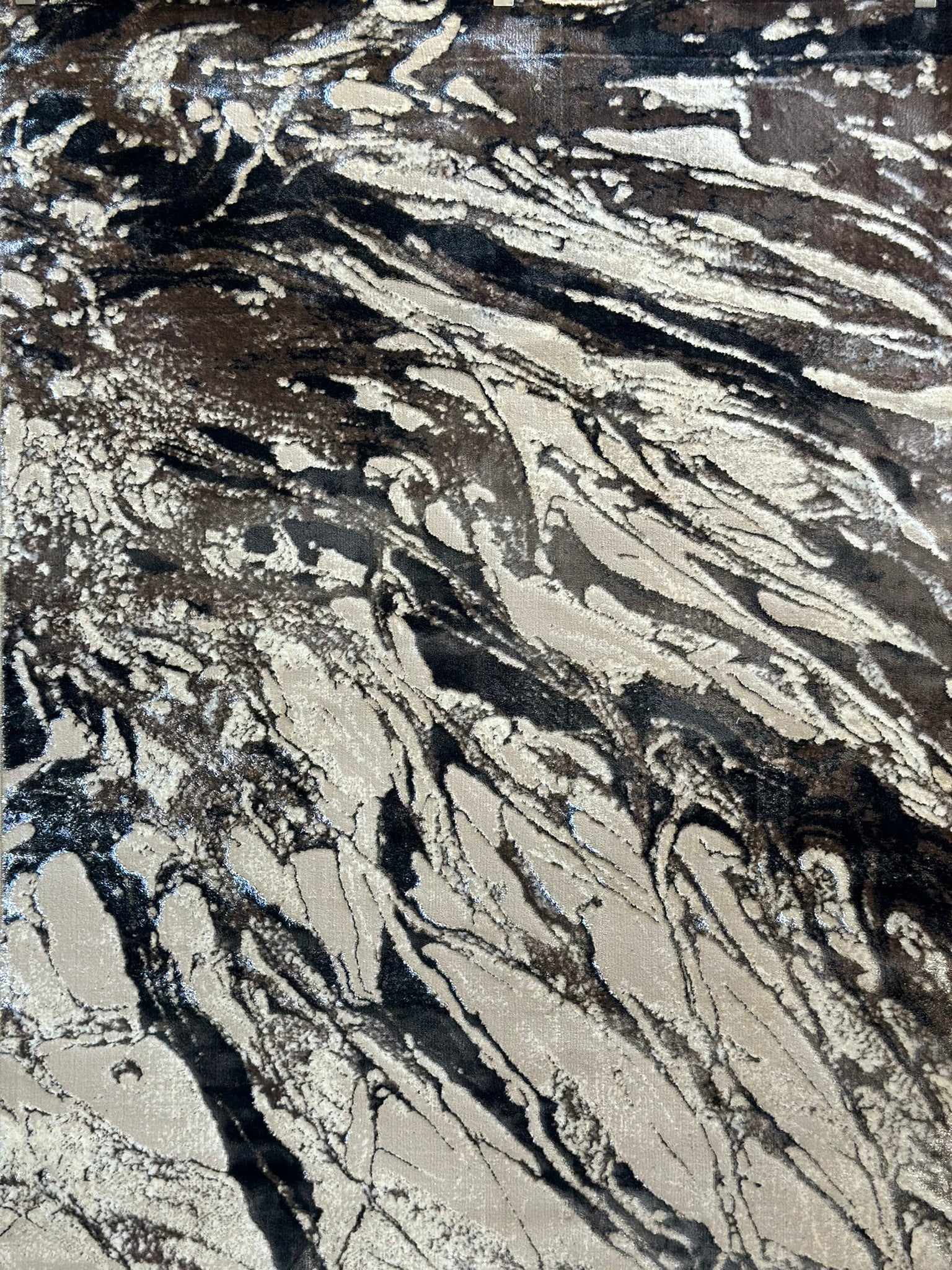 Abstract design area rug with shades of gray, black, and white.