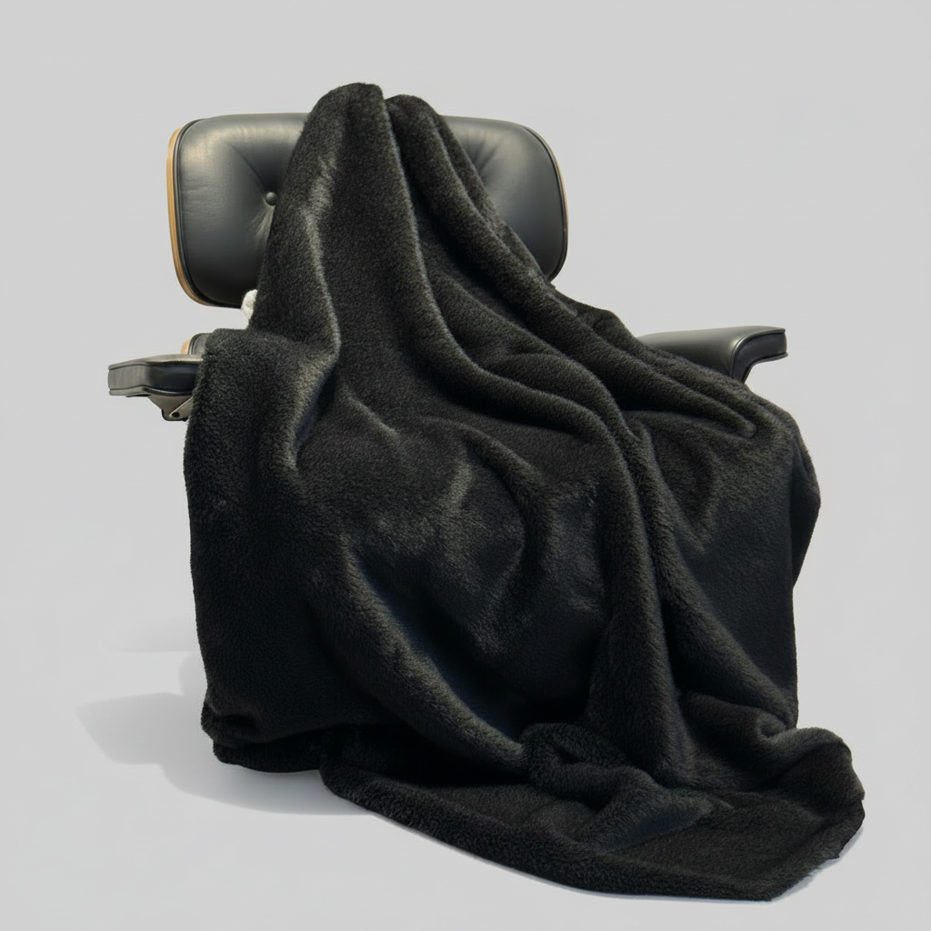 Black blanket draped over a car seat on a white background