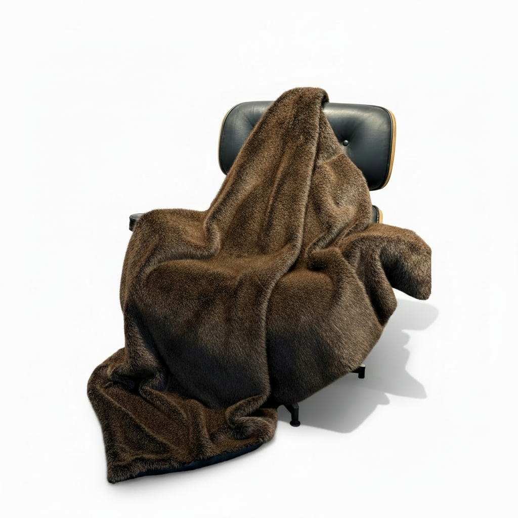 Brown blanket draped over a black office chair on a white background