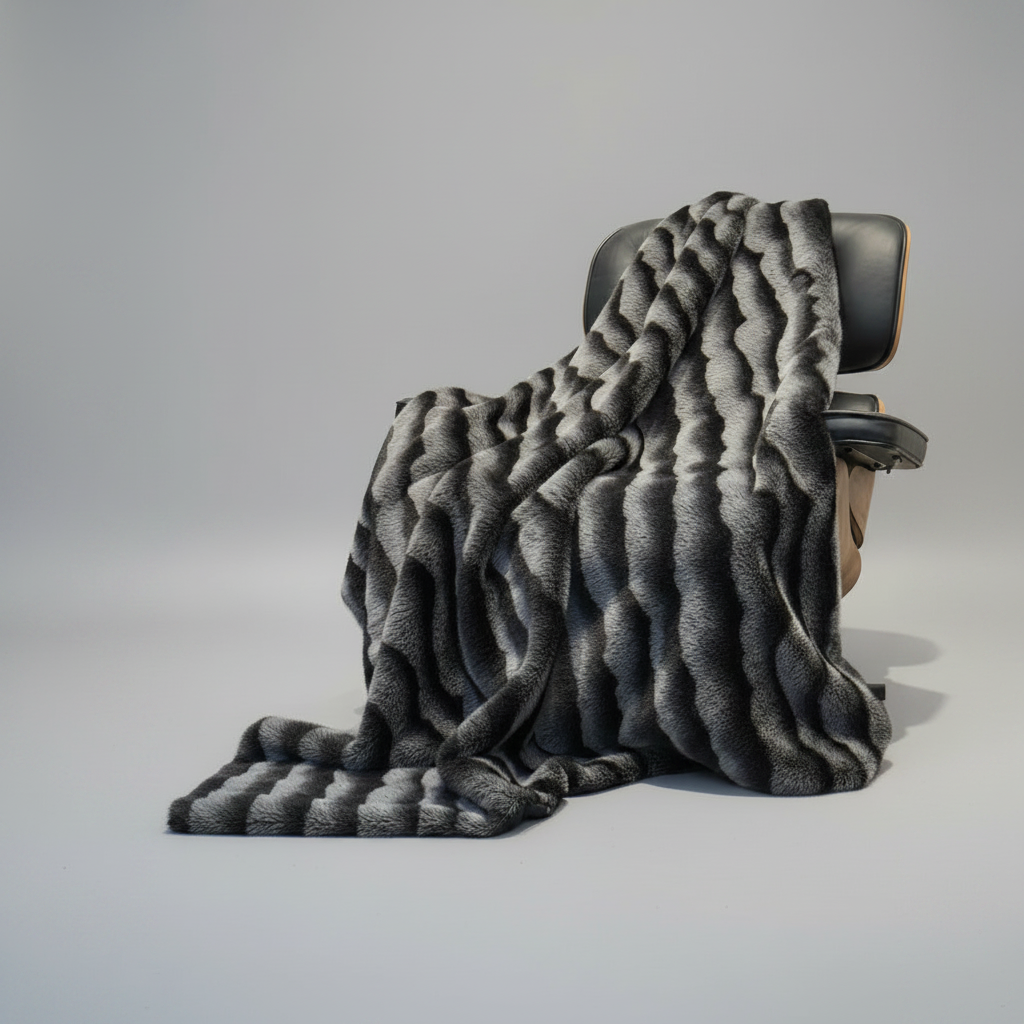 Gray textured blanket draped over a chair on a light gray background