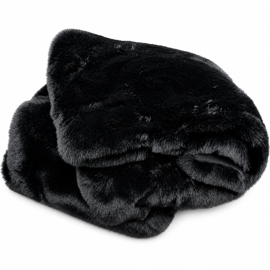 Folded black faux fur blanket on a white background