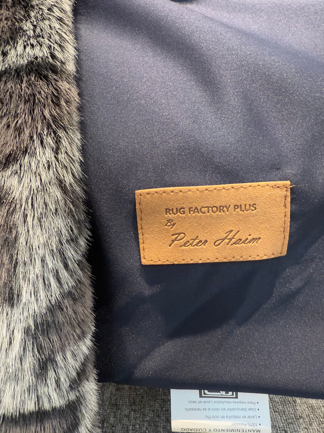 Close-up of a rug with a brand label on a textured surface