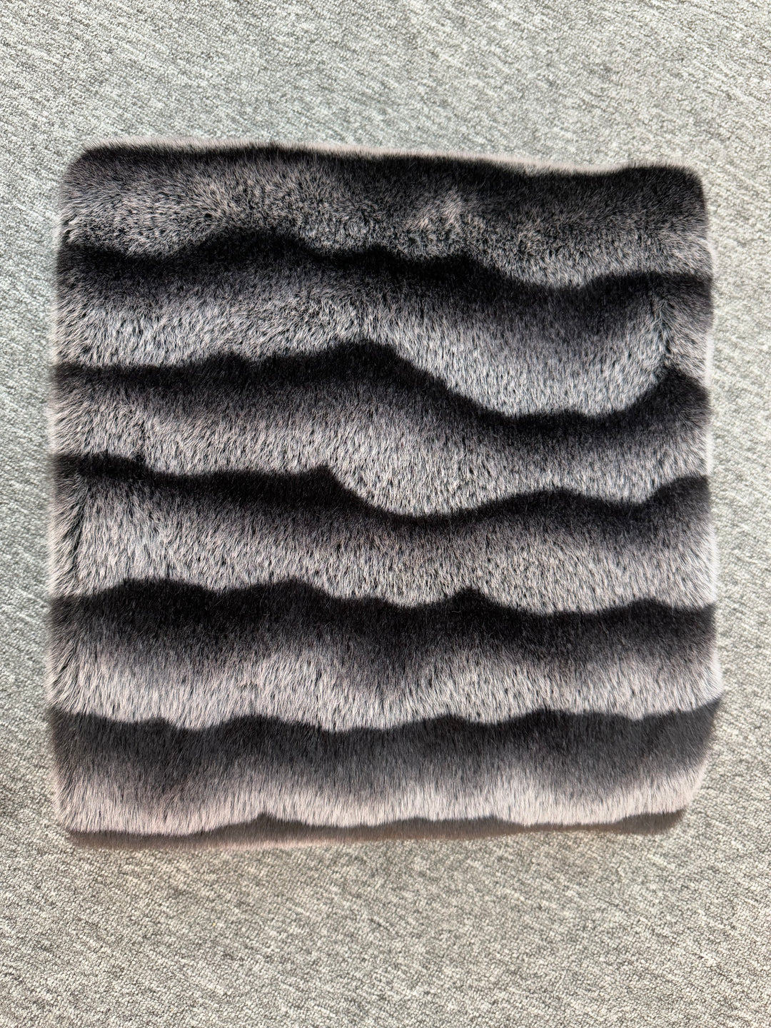 Textured gray square mat on a textured surface